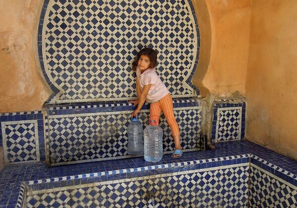 Petite fille récupérant de l'eau