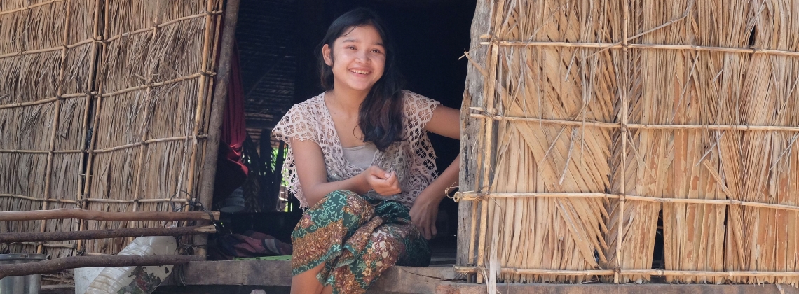 Jeune cambodgienne sur le pas de sa maison